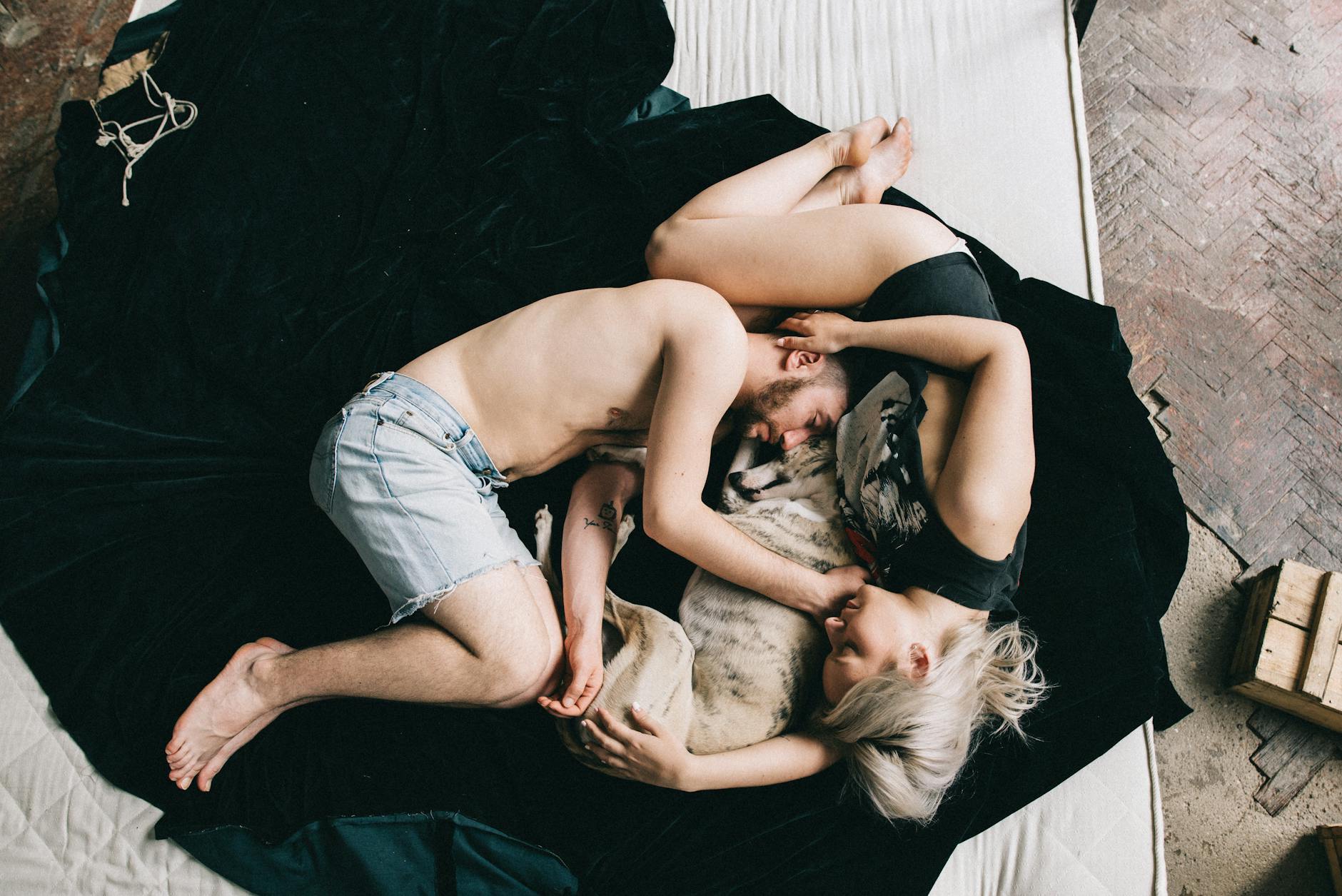 couple sleeping with pet dog