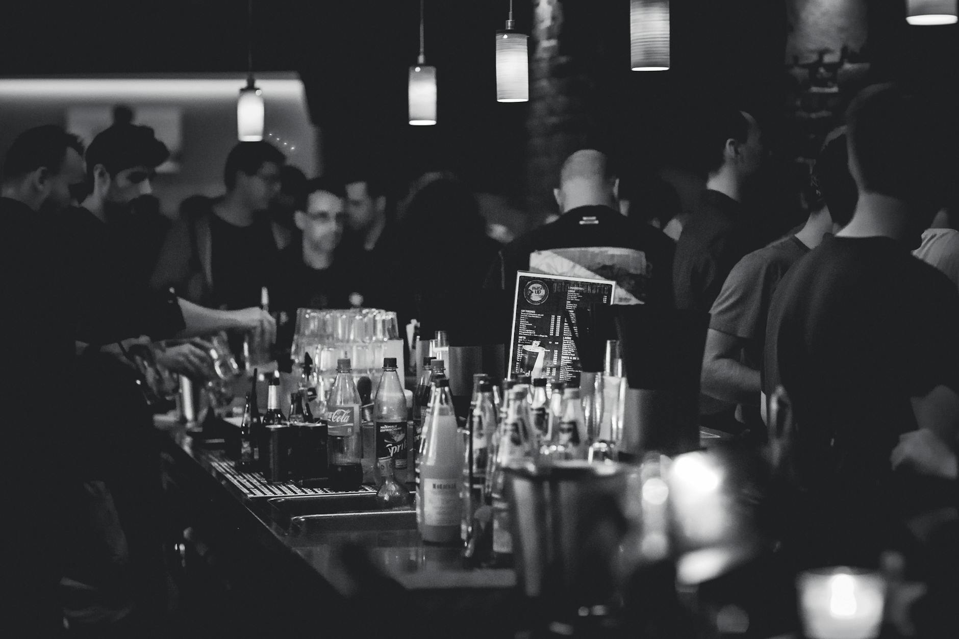 grayscale photography of bottles on top of table