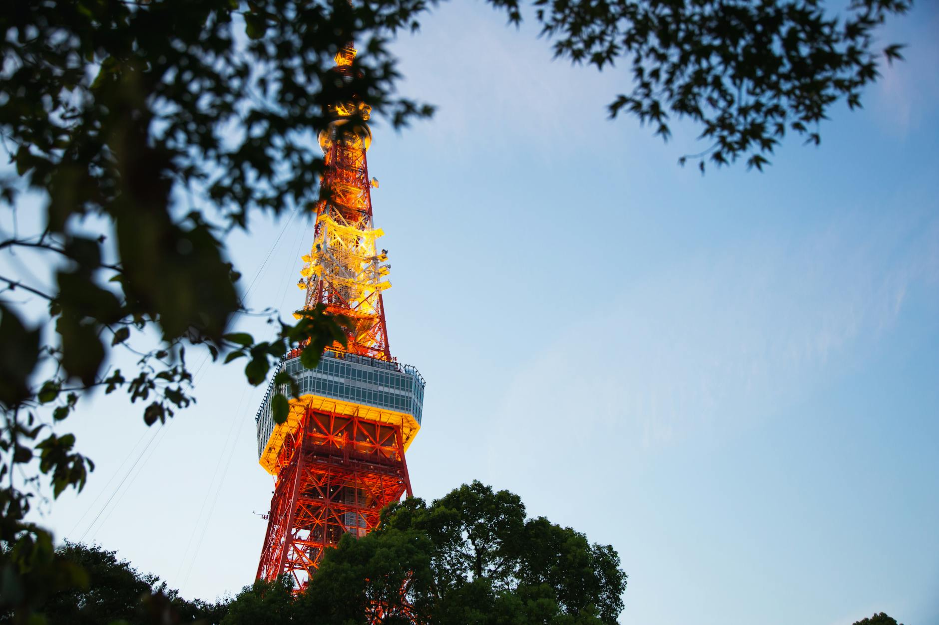 bright tv tower under blue cloudy sky in city