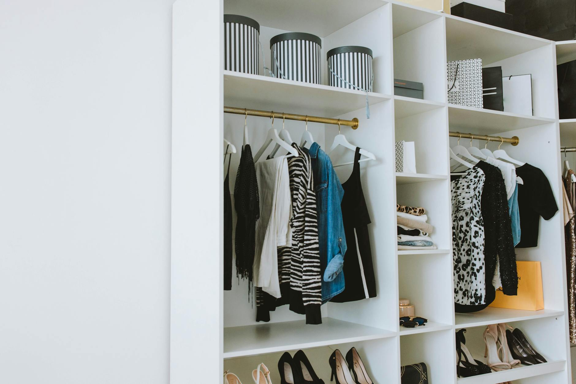 clothes hanged on white wooden cabinet