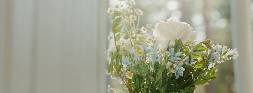 white flowers in clear glass vase