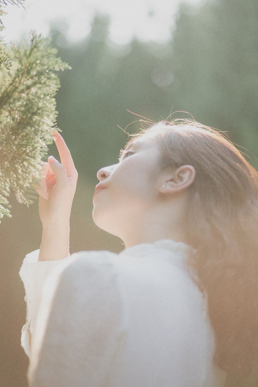 woman in white dress touching a plant